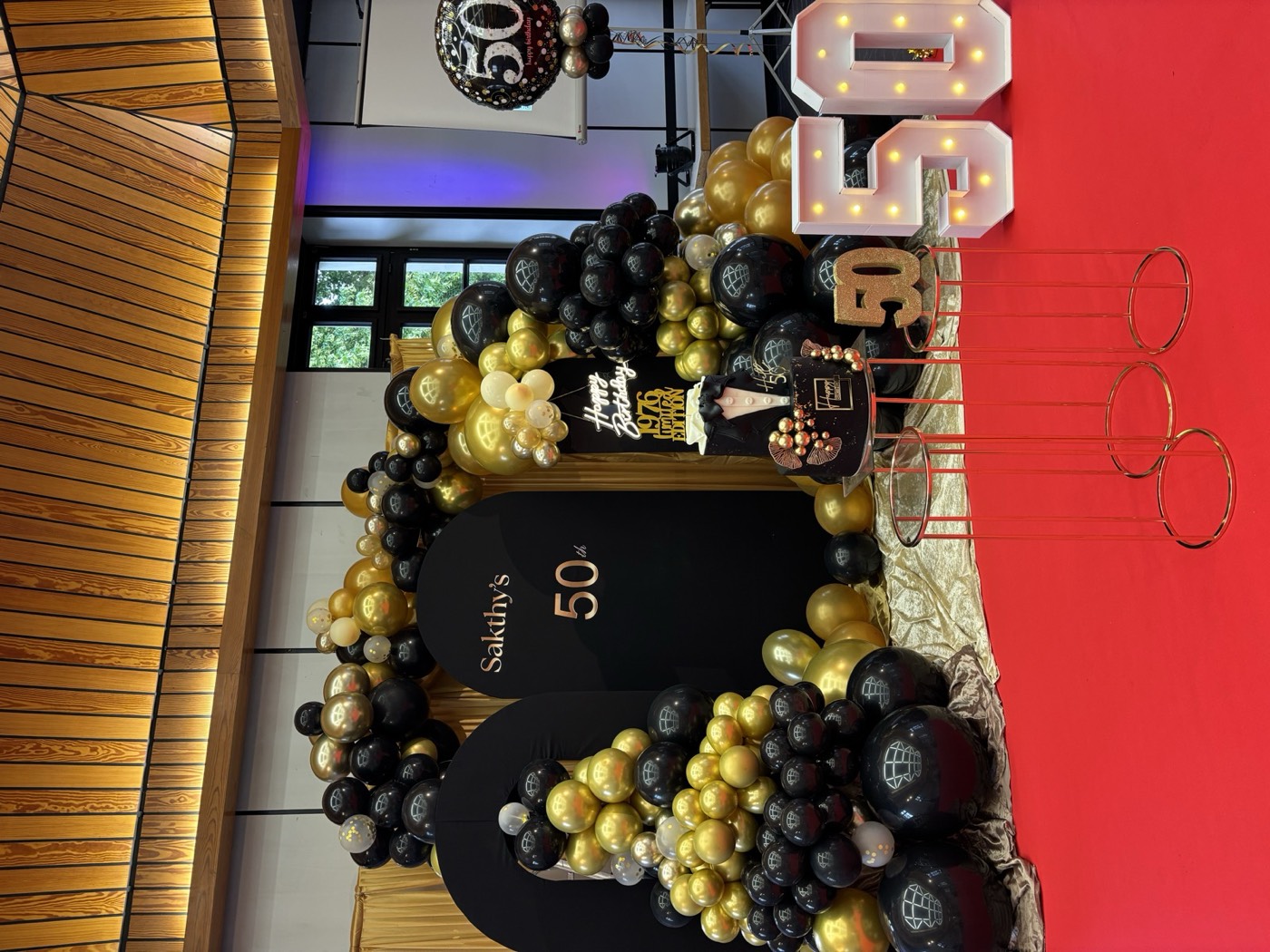 Geburtstagsdekoration zum 50. mit schwarz-goldenem Ballonbogen und Leuchtzahlen