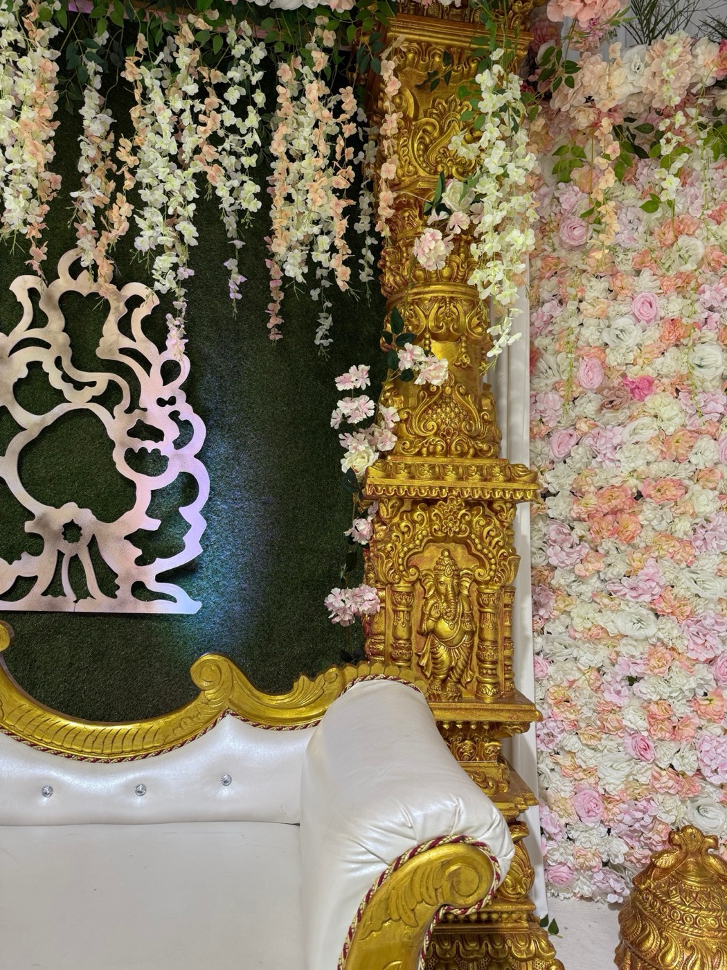Detail der Hochzeitsbühne im Sivan-Tempel: Blumenwand, goldene Säule und Ganesha-Ornament